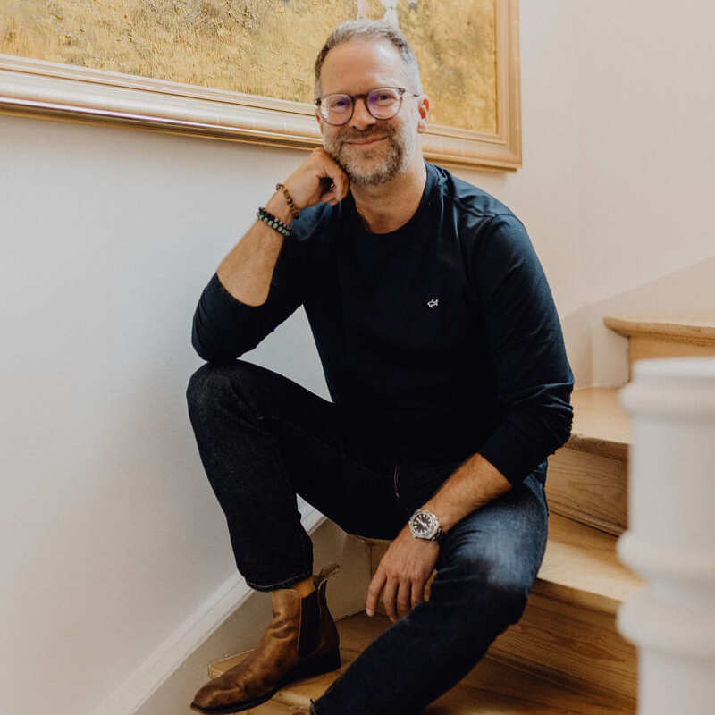 Christoph Positionierungscoach sitzt auf einer Treppe vor dem Gespräch mit Transformationscoach Barbara Weiland